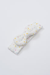 Avauma Lovely Bloom Headband in Butter Garden, featuring multicolor floral print on soft ribbed white fabric with centered bow